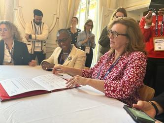 A photo of Tana Adkin KC signing a declaration of intent