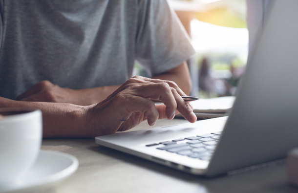 Close-up of a man's hand using a computer.